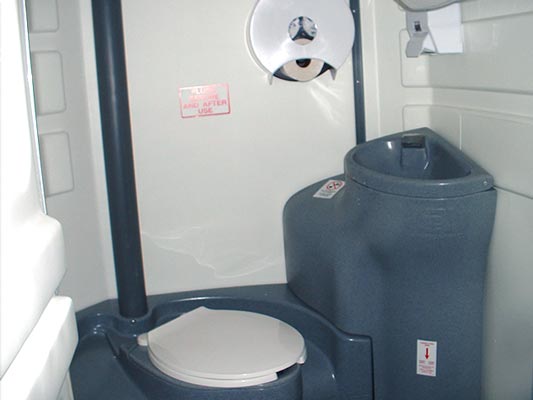 Spacious interior features a flush tank, sink and supplies